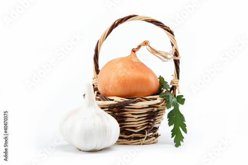 Fresh bulbs of onion in basket on a white background