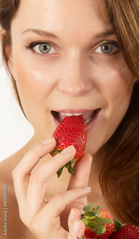 Closeup portrait of a beautiful woman eating strawberry Closeup portrait of a beautiful woman eating strawberry