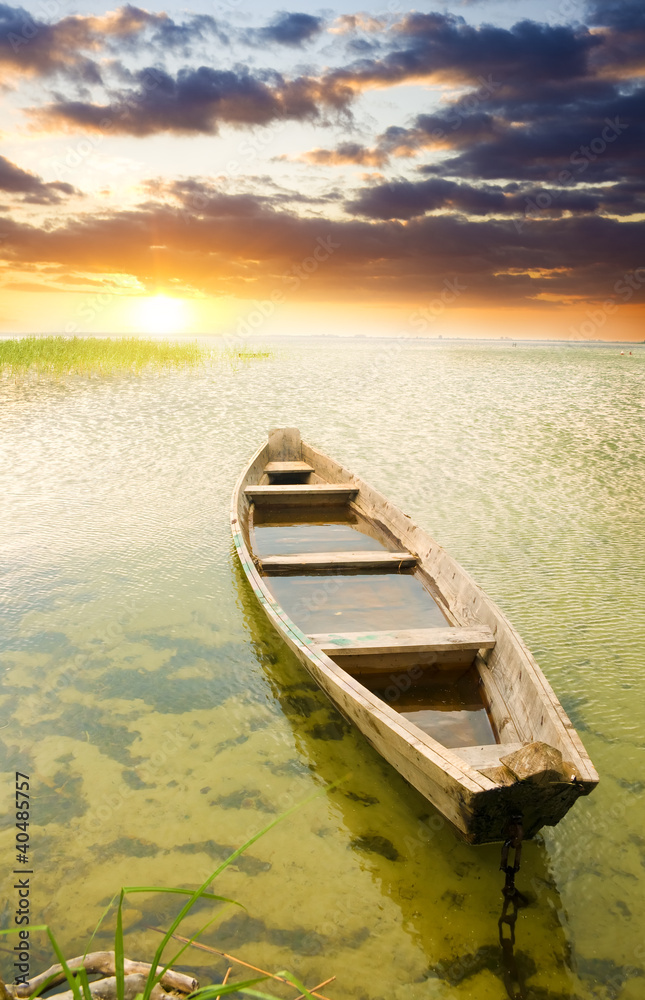 Boat at coast against asunset.