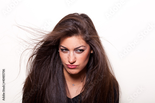 Wondering.. Young confident woman with long hair posing