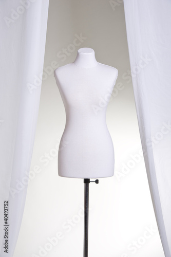 Clothing mannequin white on a light background near the curtains