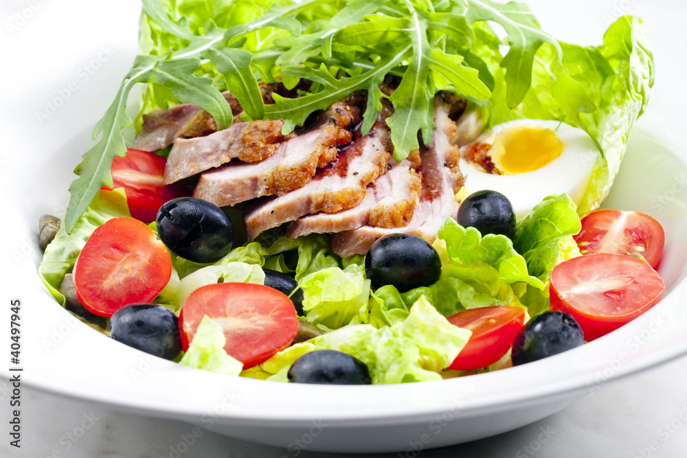 vegetable salad with fried duck breast slices and egg
