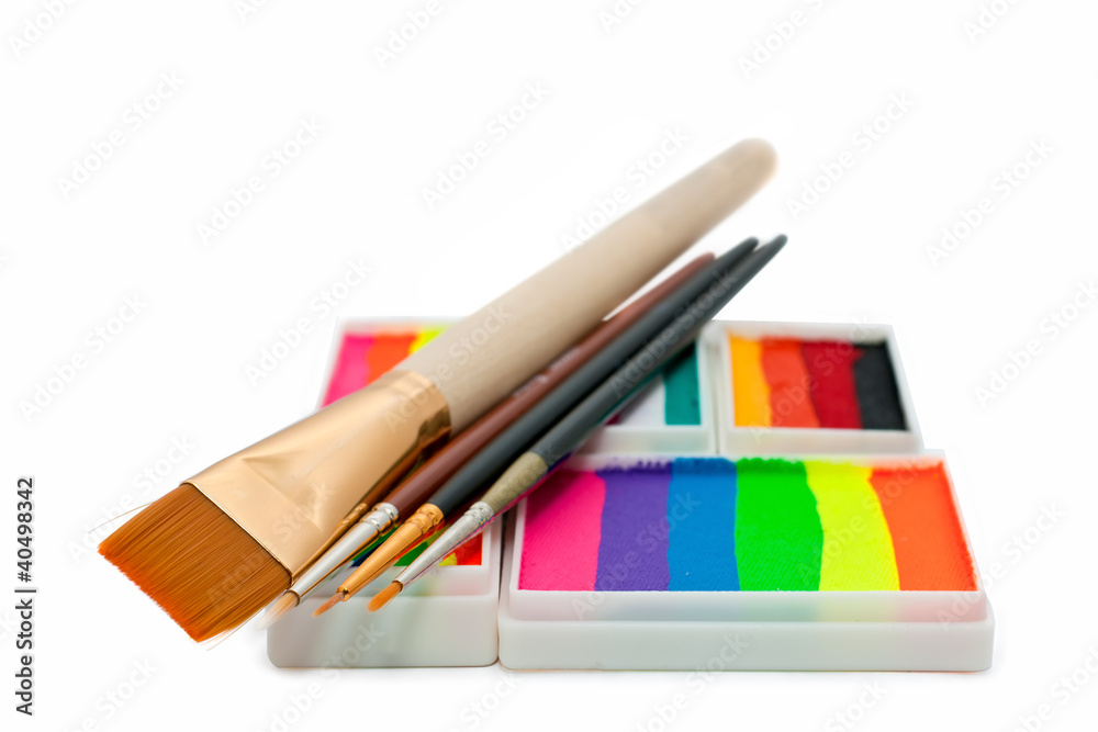 Fototapeta premium face-paints rainbow cakes and brushes over white background