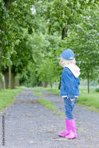 little girl wearing rubber boots in spring alley © Richard Semik