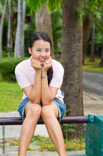 asian woman sitting and smile on bench