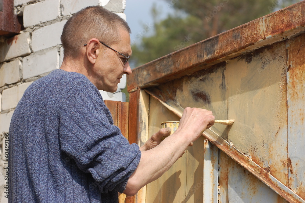 Man painting gate Ukraine Man painting gate Ukraine