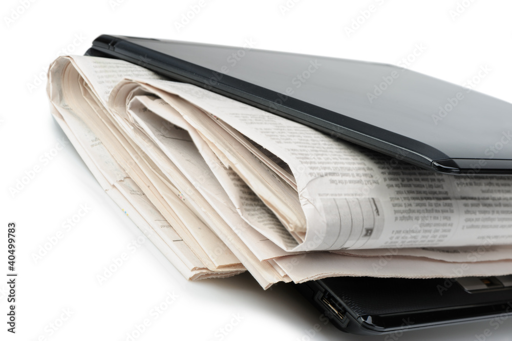 Newspaper and a laptop Newspaper and a laptop