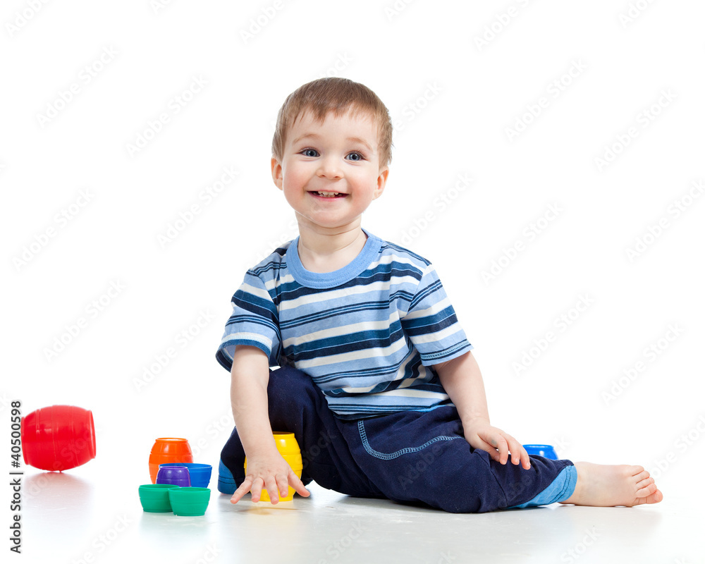 Funny little child is playing with cup toys while sitting on flo Funny little child is playing with cup toys while sitting on flo