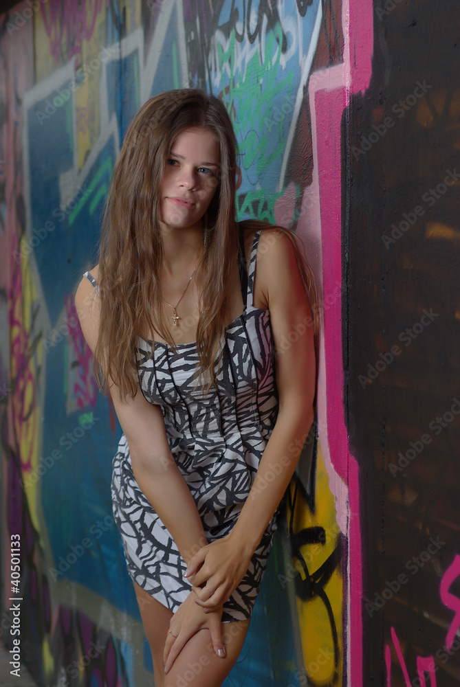 Slim girl against graffiti wall