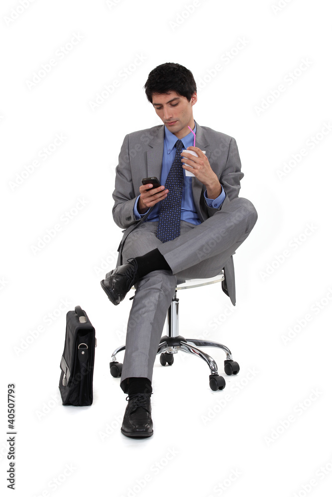 businessman drinking beverage through straw reading sms businessman drinking beverage through straw reading sms