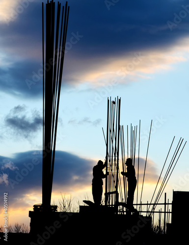 Silhouette of workers and unfinished building
