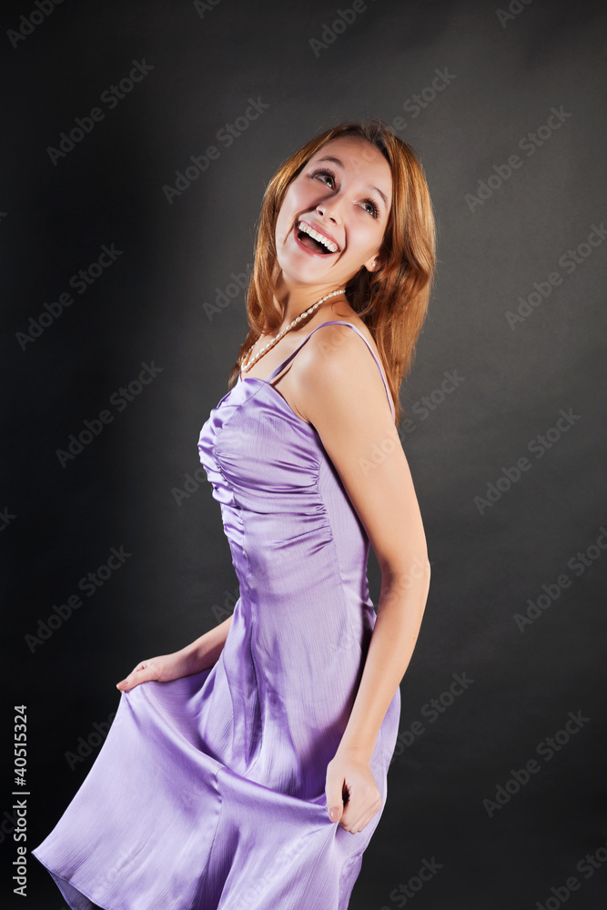 Obraz premium Happy young woman in a lilac dress