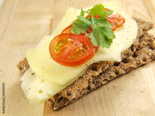 Cracker with cheese, tomato and parsley