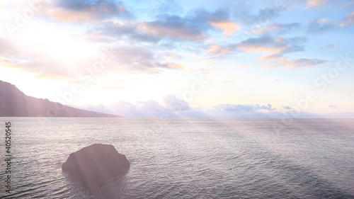 Seascape at sunrise with rays of the sun through the clouds