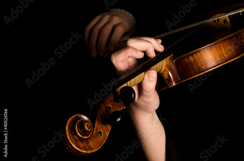 Female hands play a violin on the black