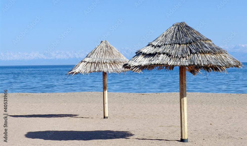 Fototapeta premium Two beach umbrellas on the sand