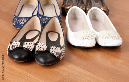 several pairs of female flat shoes on wooden background