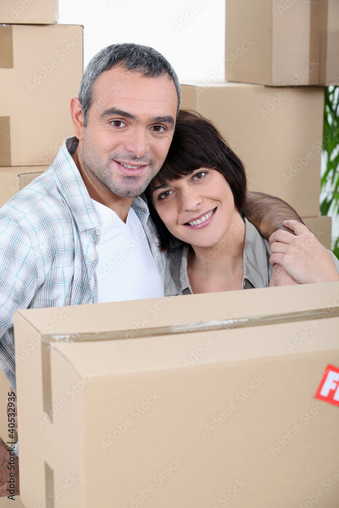 a couple in front of a pile of cartons a couple in front of a pile of cartons