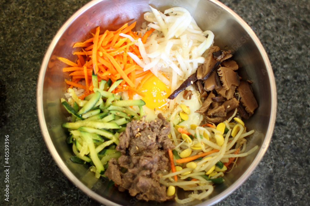 Bibambap in a metal bowl at a Korean restaurant.