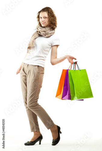 Happy beautiful young woman holding multicolored paper bags