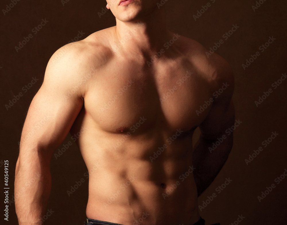 Muscular man , isolated on brown background