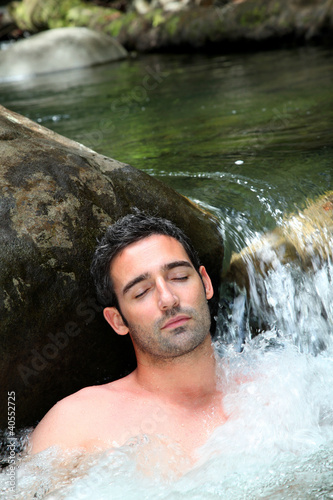 Closeup of man relaxing in natural river spa