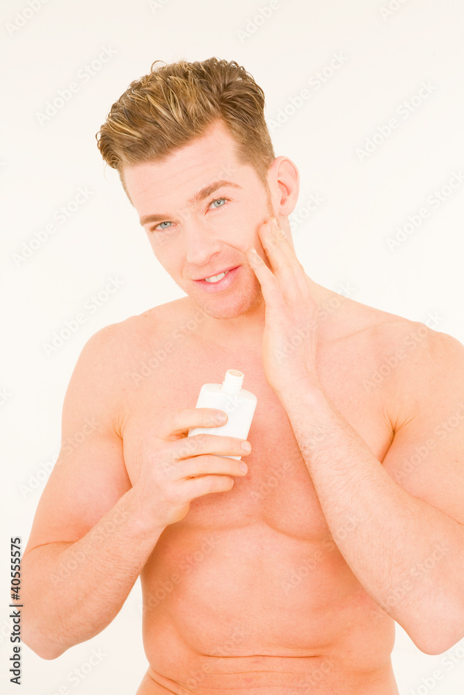 Foto Young man applying aftershave