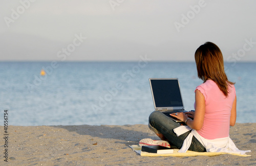 Woman Working at Computer on the Beach