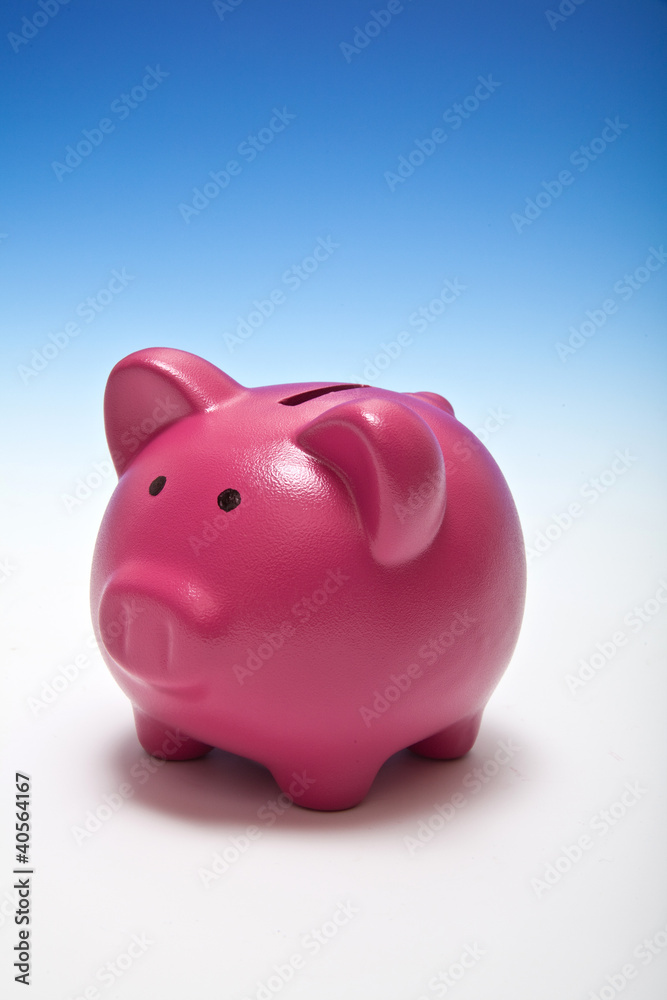 Piggy bank or money box on a graduated blue studio background.
