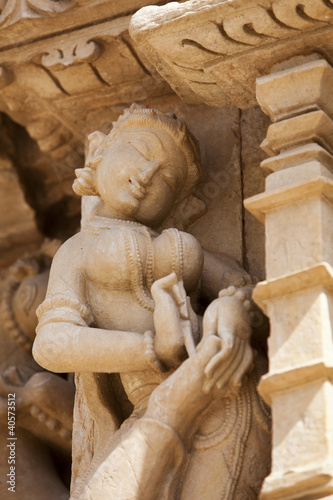 Woman picking thorn from her foot - Khajuraho Temples