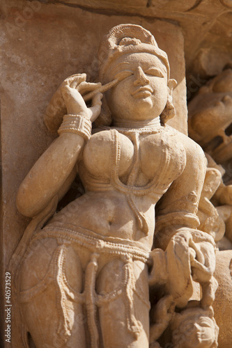 Khajuraho carving of a woman applying makeup