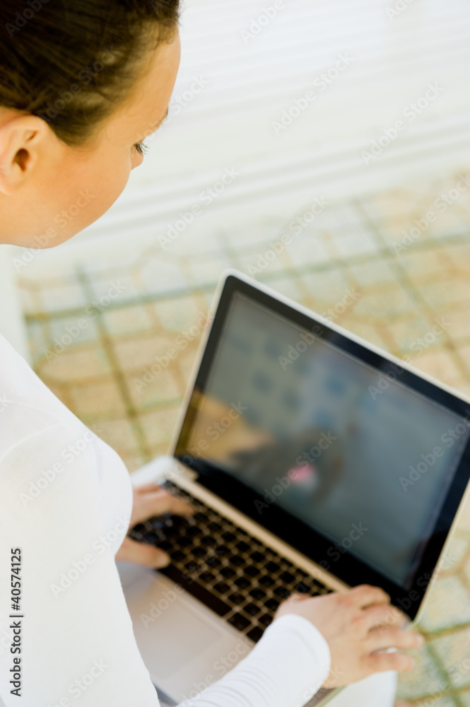 Businesswoman sitting on bench working on laptop in park Businesswoman sitting on bench working on laptop in park