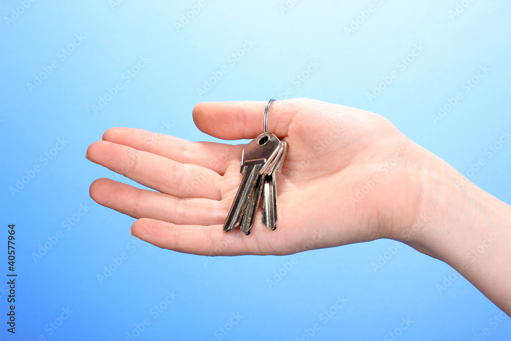 Keys in hand on blue background