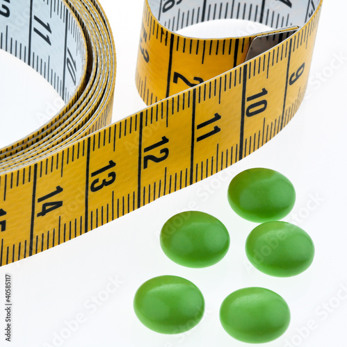 Maßband und Tabletten, als Symbol für Diätpillen photo