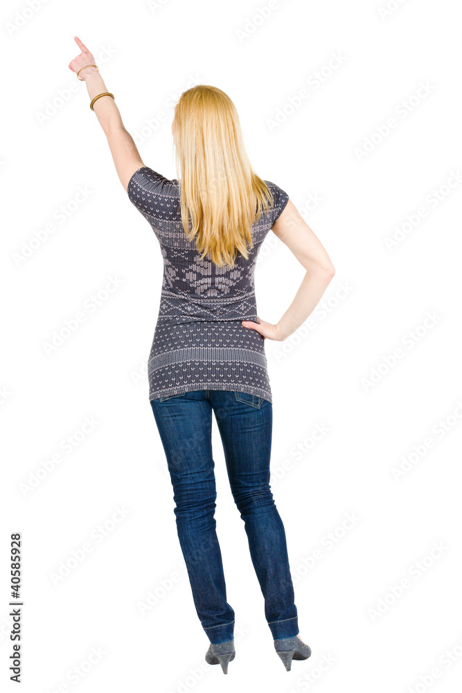 Back view of young brunette woman pointing at wall Back view of young brunette woman pointing at wall
