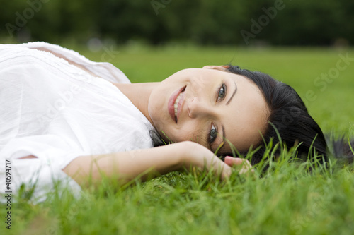 Smiling woman laying on grass © Monika Olszewska
