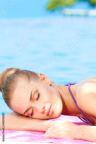 Woman sleeping next to swimming pool