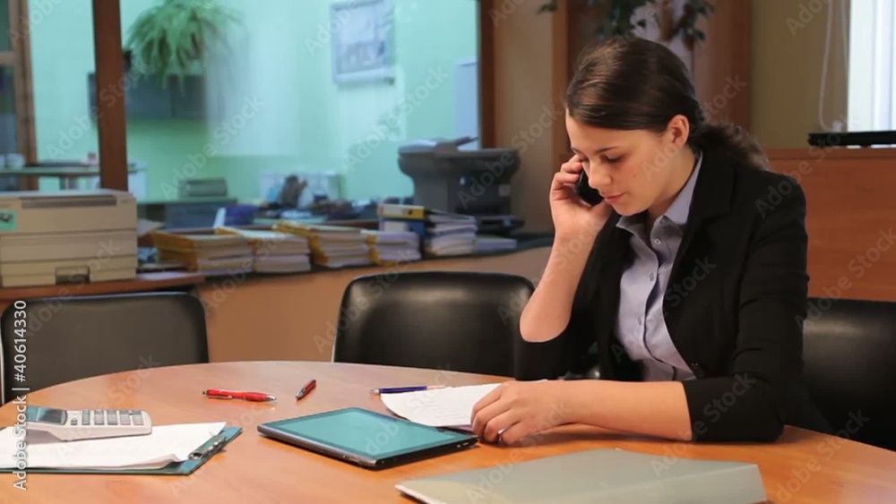 Young businesswoman talking on the phone in office Young businesswoman talking on the phone in office