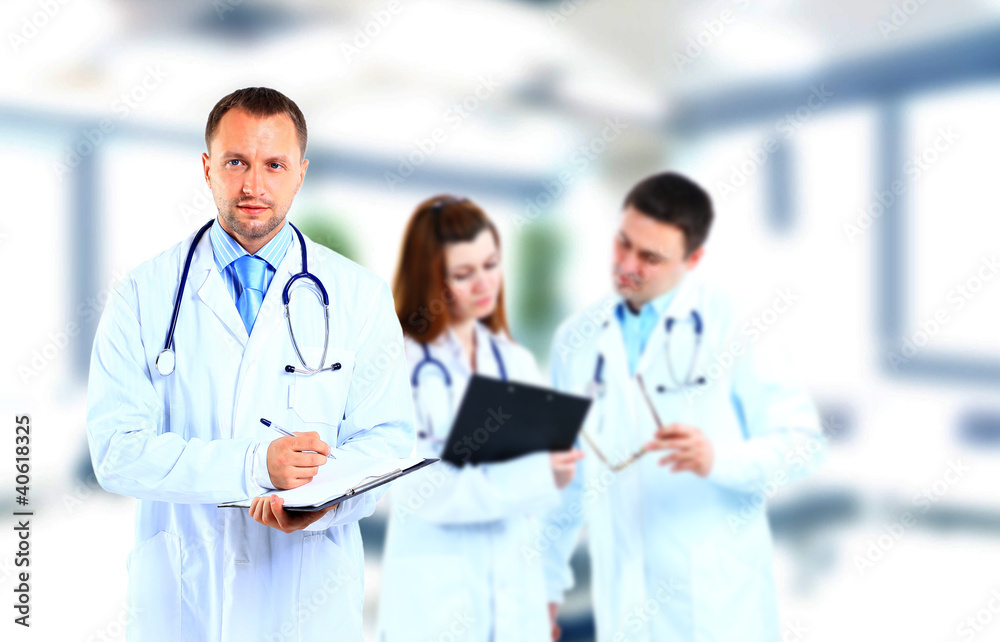 Portrait doctor smiling with colleague in background Portrait doctor smiling with colleague in background