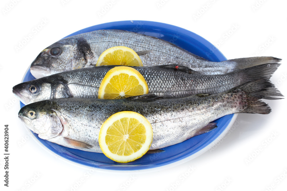 Fresh fishes with lemon on plate isolated on white Fresh fishes with lemon on plate isolated on white