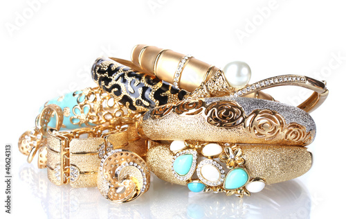 Beautiful golden bracelets and rings isolated on white