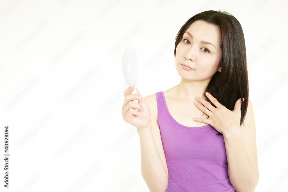 スキンケアをしている手鏡を持った女性 スキンケアをしている手鏡を持った女性