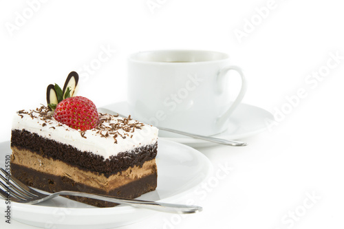 Piece of chocolate cake with strawberry decorate on top and cup