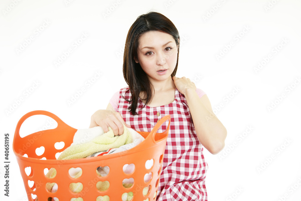 洗濯物を持った肩こりに悩む女性 洗濯物を持った肩こりに悩む女性