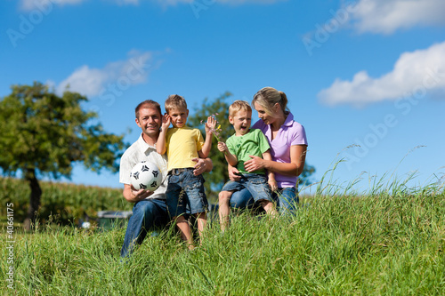 Familie mit Kindern und Fußball auf einer Wiese © Kzenon