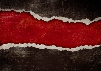 red hole with torn edges in black grunge paper