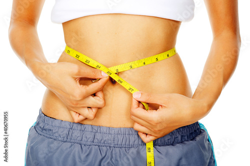 Woman holding measuring tape around waist