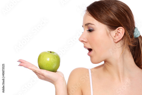 A smiling girl with green apple, on white