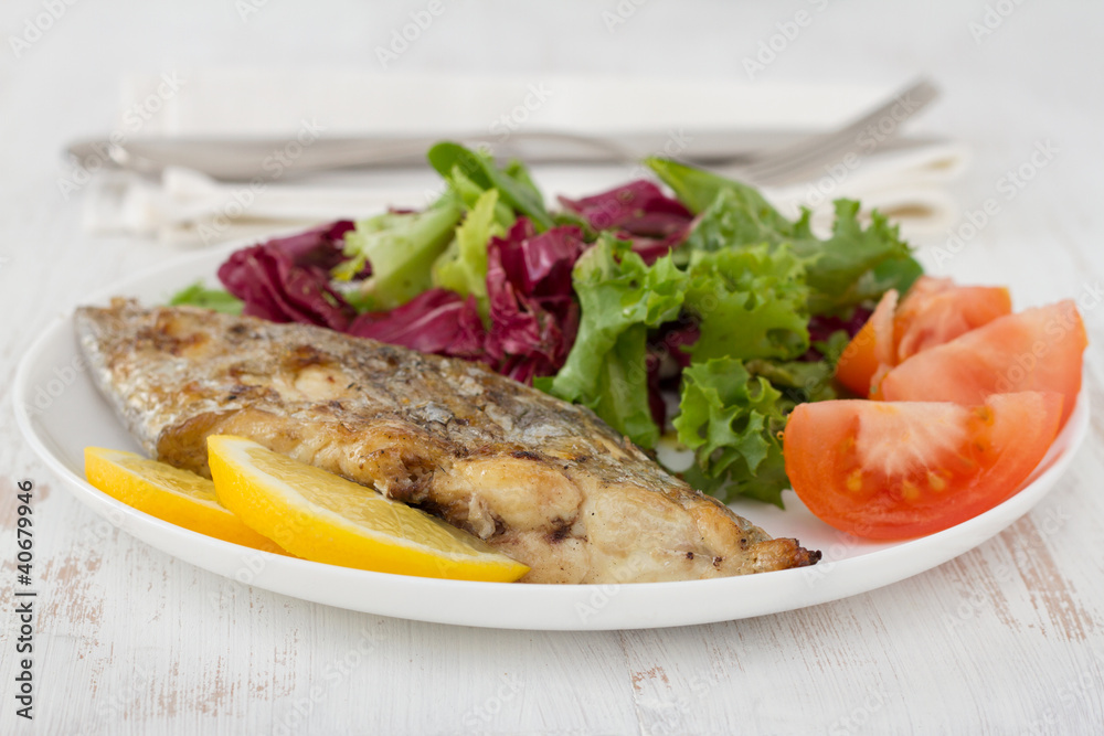 grilled swordfish with salad on the plate