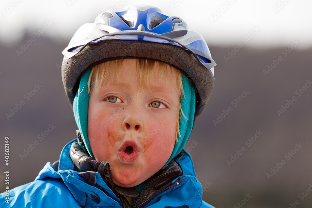 Dreckspatz mit Helm zieht Grimasse Dreckspatz mit Helm zieht Grimasse